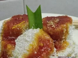 Lupis ditaburi kelapa parut dan disiram kinca gula merah.